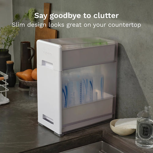 White Baby Brezza bottle drying rack on a countertop with text 'Say goodbye to clutter, Slim design looks great on your countertop'. - product thumbnail