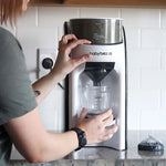 Baby Brezza Formula Pro Advanced with a person filling a bottle. - product thumbnail
